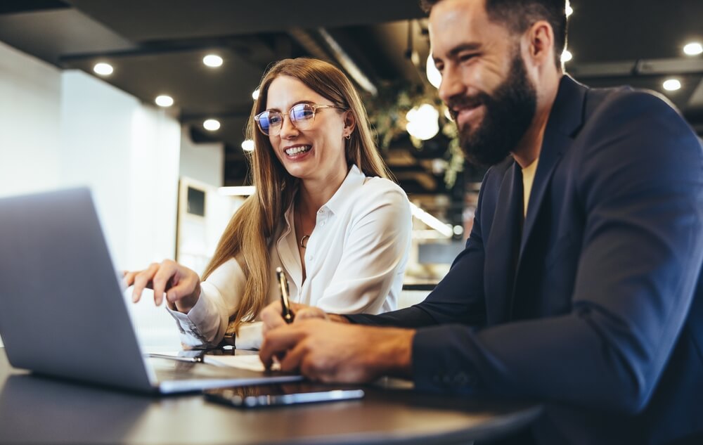 homem e mulher olhando computador juntos